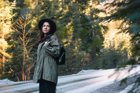 Happy girl with hat in forest at mountain road background, Relax time on holiday concept travel ,color of vintage tone and soft focusの写真素材