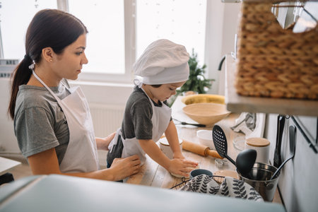 Young happy mom and her baby cook cookies at home in the kitchen. Christmas Homemade Gingerbread....
