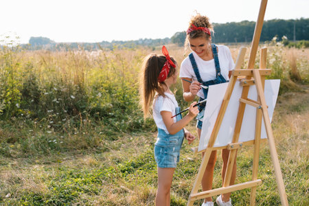 family, children and people concept - happy mother and daughter drawing and talking over green background. mother's dayの写真素材