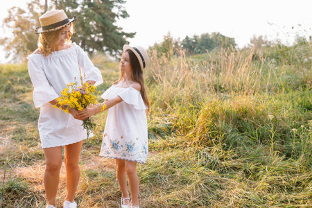 Mother and daughter having fun in the park. Happiness and harmony in family life. Beauty nature scene with family outdoor lifestyle.の写真素材