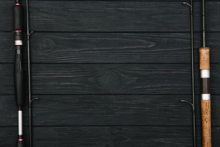 Fishing tackle - fishing spinning, hooks and lures on darken wooden background. top viewの写真素材