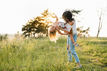 Stylish mother and handsome daughter having fun on the nature. happy family concept. Beauty nature scene with family outdoor lifestyle. family resting together. Happiness in family life. mother's dayの写真素材