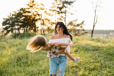 Stylish mother and handsome daughter having fun on the nature. happy family concept. Beauty nature scene with family outdoor lifestyle. family resting together. Happiness in family life. mother's dayの写真素材