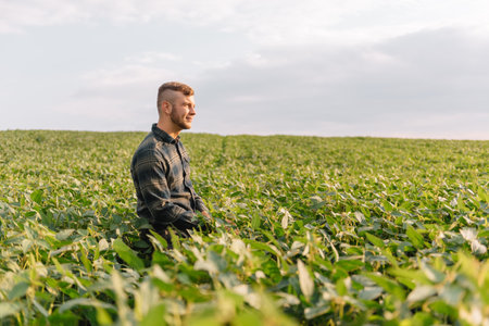 Portrait of young farmer standing in soybean fieldの写真素材