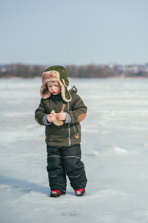 boy fishing on winter. Cute boy catches fish in the winter lake. Winter. Outdoorの写真素材