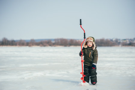 boy fishing on winter. Cute boy catches fish in the winter lake. Winter. Outdoorの写真素材