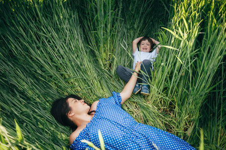 Stilish mother and handsome son having fun on the nature. happy family concept. Beauty nature scene with family outdoor lifestyle. Happy family resting together. Happiness in family life. mother's day.の写真素材