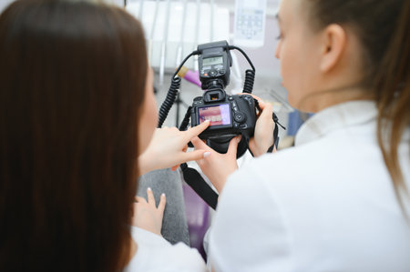 Female dentist photographs her patient's teeth in a dental chair