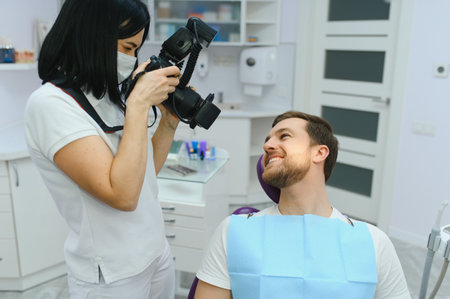dentist clinic. A female dentist photographing her client's teeth during an appointment at the dental clinicの写真素材