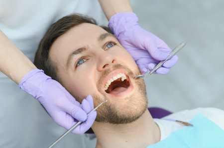 Young man at the dentist. Dental care, taking care of teeth. Picture with copy space for backgroundの写真素材