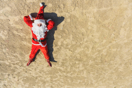 Santa Claus enjoy sunbathing at tropical ocean beach in turquoise waves, Christmas and New Year vacation destinations in hot countries conceptの写真素材
