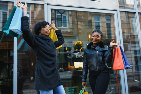 young black women going shopping. African American girls with shopping bags go shoppingの写真素材