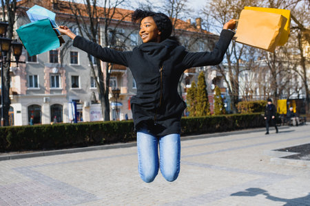 A shopping black woman carrying shopping bags outdoorの写真素材