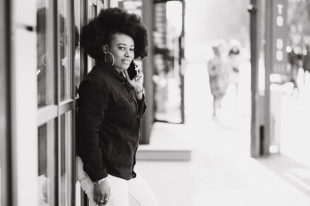 Outdoor close up portrait of young cute happy smiling african american woman with afro hairstyle.