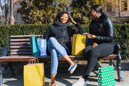 Two Smiling Black Girlfriends Shopping and Chatting