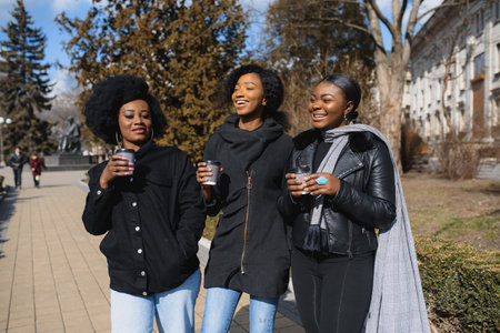 stylish african american girls drinking coffee on the streetの写真素材