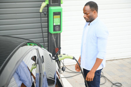 Man charging his electric car at charge station.