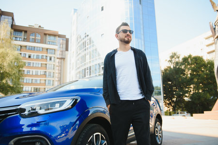 Handsome young man in standing near car outdoors