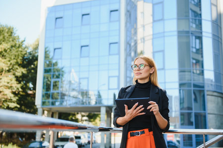 Happy business woman using tablet pc in office districtの写真素材