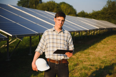 Inspector Engineer Man Holding Digital Tablet Working in Solar Panels Power Farm, Photovoltaic Cell...