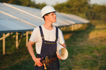 solar power plant. man standing near solar panels. Renewable energy.の写真素材