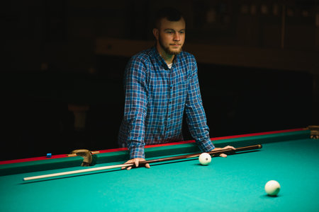 young man playing billiard. Spending free time gambling