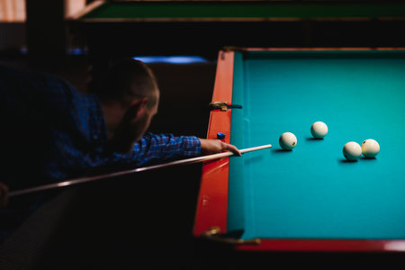 the player takes aim at the ball in Billiards