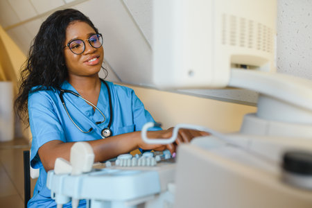 Young cheerful African woman operator of an ultrasound scanning machine analyzing diagnostics...