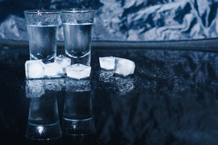 Vodka. Shots, glasses with vodka with ice .Dark background. Copy space .Selective focusの写真素材
