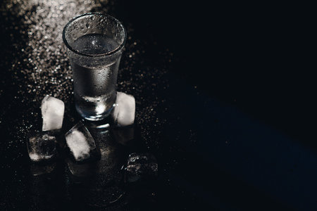 Vodka. Shots, glasses with vodka with ice .Dark background. Copy space .Selective focusの写真素材