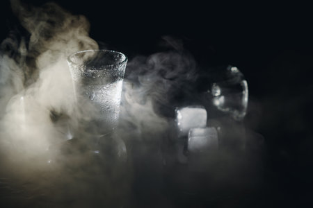 Vodka. Shots, glasses with vodka with ice .Dark background. Copy space .Selective focusの写真素材