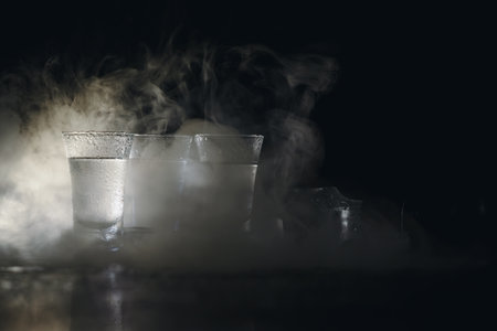 Vodka in shot glasses on dark background.の写真素材
