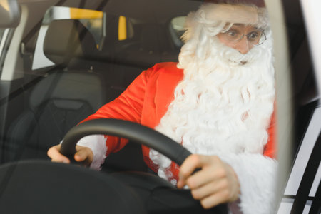 Authentic Santa Claus driving his modern car, outdoors