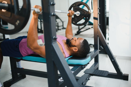 Weight lifter at the bench press lifting a barbell on an bench