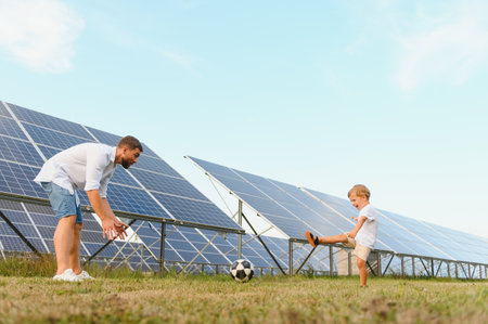 Father and son playing football in garden of solar paneled.の写真素材