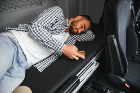Truck driver enjoying comfortable cabin bed inside his truck.