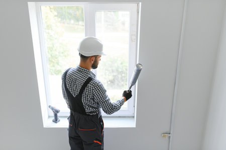 Construction worker installing window in house.の写真素材