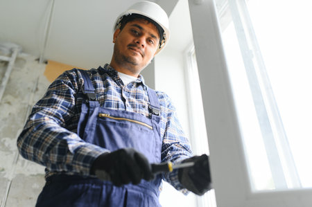 Indian Construction worker installing window in houseの写真素材