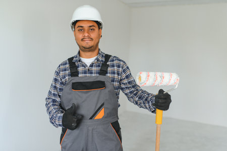 Indian worker makes repairs in an apartment.の写真素材
