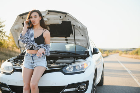 Sad woman depressed not knowing what to do with broken car.の写真素材