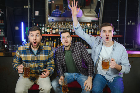 Soccer fans cheering for favorite team while enjoying drinks. Group of supporters celebrating...