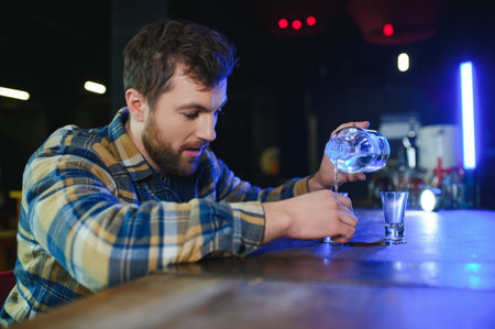 Sad man sitting at bar counter, alcohol addiction.の写真素材