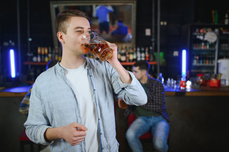 Tasting a good beer. Portrait of thoughtful men drinking beer at the bar.の写真素材
