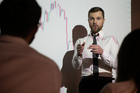Man is standing near projector and showing graphs and business graphs