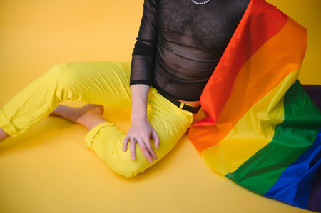 Handsome young man with pride movement LGBT Rainbow flag on shoulder against white background. Man with a gay pride flagの写真素材