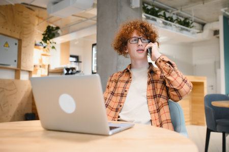 Cheerful male freelancer making telephone call share good news about project working in cafe...