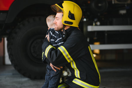 Firefighter holding child boy to save him in fire and smoke,Firemen rescue the boys from fire.の写真素材