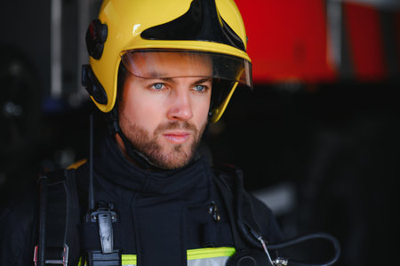Photo of fireman with gas mask and helmet near fire engine.