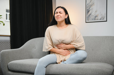 Menstrual pain, woman with stomachache suffering from pms at home, endometriosis, cystitis and other diseases of the urinary systemの写真素材