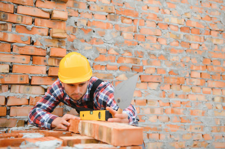 Construction worker in uniform and safety equipment have job on building.の写真素材